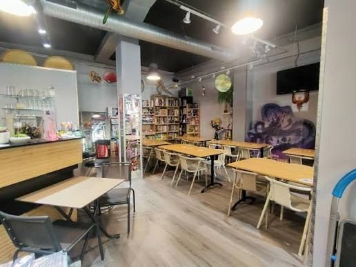 La salle de L'Espace Fantastik : tables en bois, mur de jeux et fresque